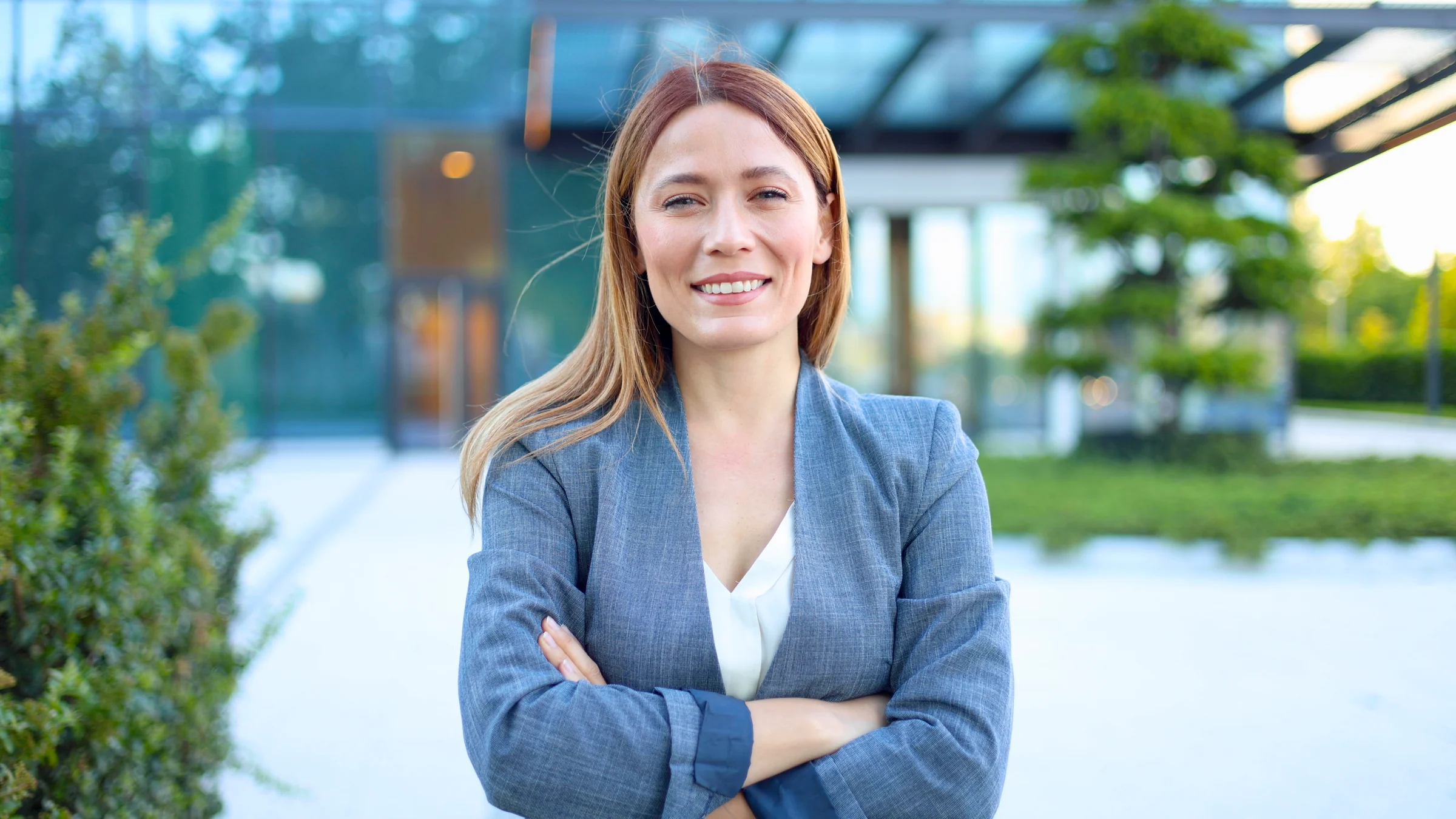 Portrait of a beautiful, young businesswoman enjoying outside, in front of her company building